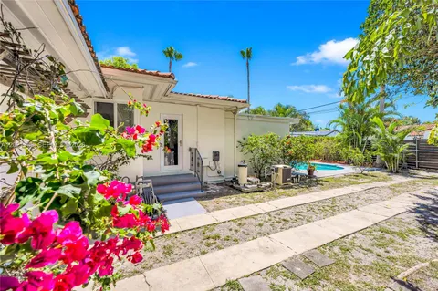 a front view of a house with flower garden