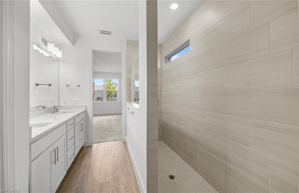 15629 Northridge Road Punta Gorda, FL 33982 - Photo 14 of 26 a bathroom with a double vanity sink and mirror with shower