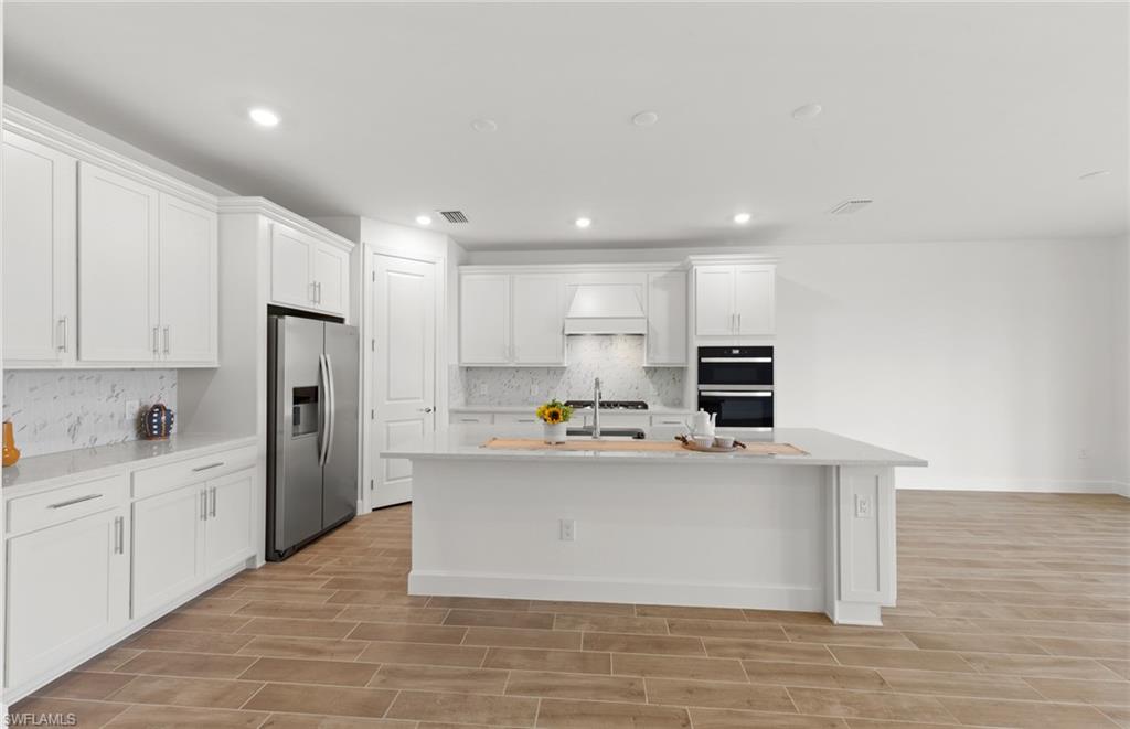 15629 Northridge Road Punta Gorda, FL 33982 - Photo 6 of 26 a view of a kitchen with stainless steel appliances a white stove top oven and a refrigerator