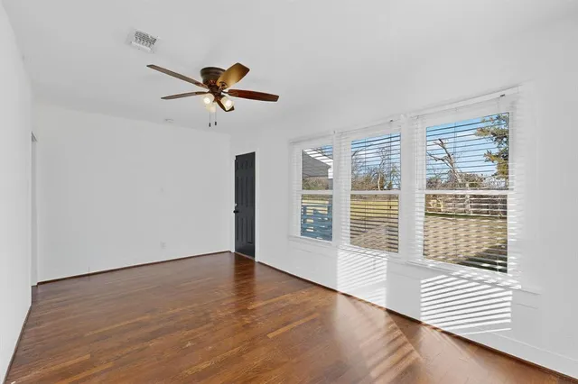 a view of a livingroom with wooden floor and a ceiling fan