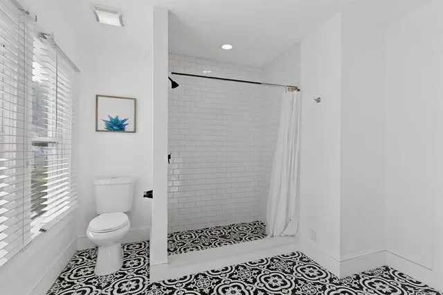a bathroom with a toilet and a shower