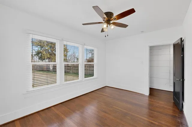 a view of a big room with wooden floor and windows
