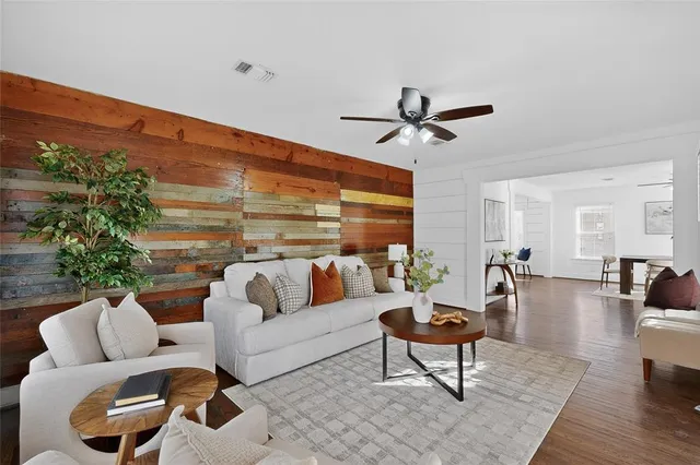 a living room with furniture a ceiling fan and a rug