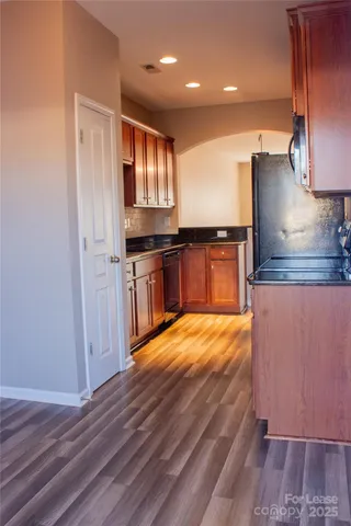 a large kitchen with stainless steel appliances granite countertop a stove a sink and a refrigerator