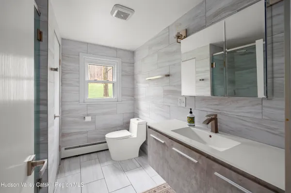 a bathroom with a sink toilet a mirror and shower