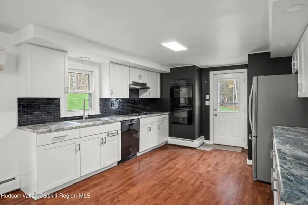 a kitchen with granite countertop a sink stove and refrigerator