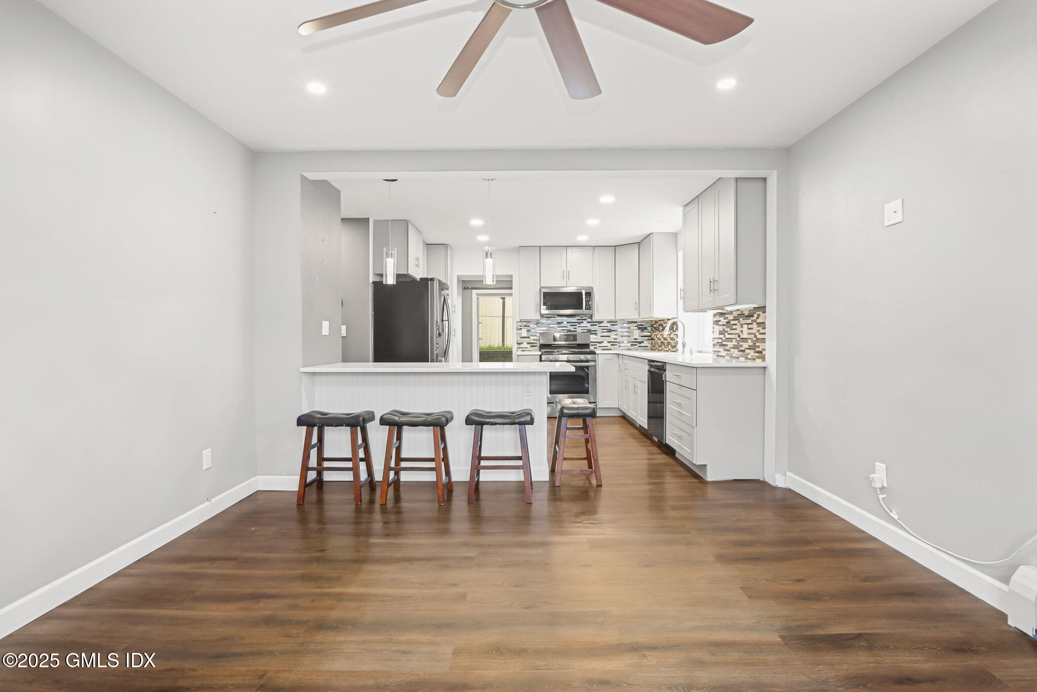 43 Cos Cob Avenue, Unit 1 Cos Cob, CT 06807 - Photo 2 of 10 a view of a kitchen with dining table and chairs