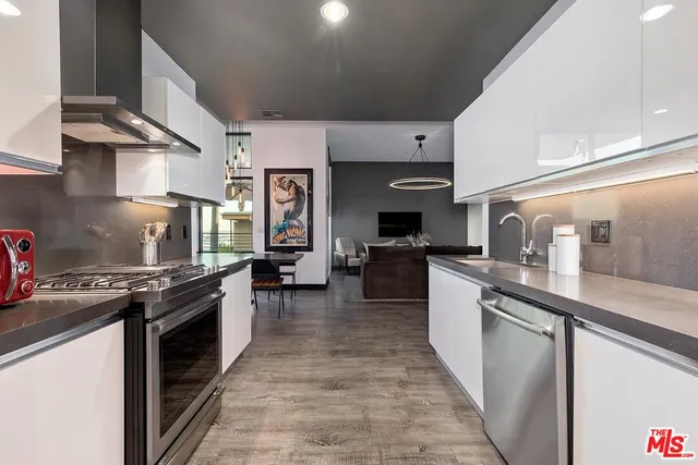 a kitchen with stainless steel appliances granite countertop a stove a sink dishwasher and a refrigerator