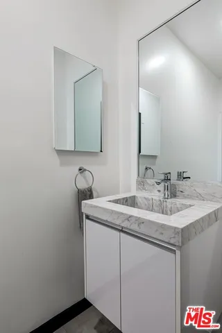 a bathroom with a granite countertop sink and a mirror