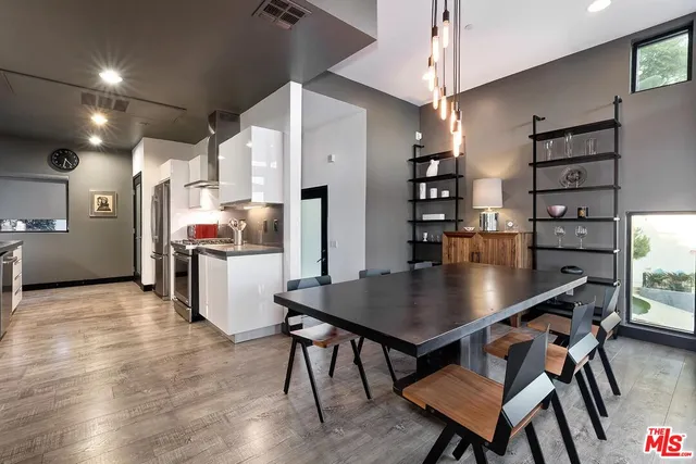 a kitchen with stainless steel appliances a table chairs and a refrigerator