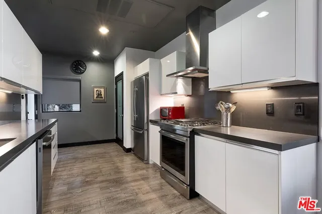 a kitchen with stainless steel appliances granite countertop a sink a stove and a refrigerator