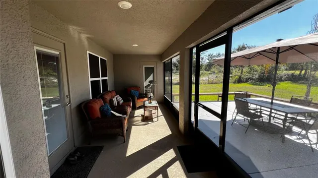 a living room with furniture and a floor to ceiling window