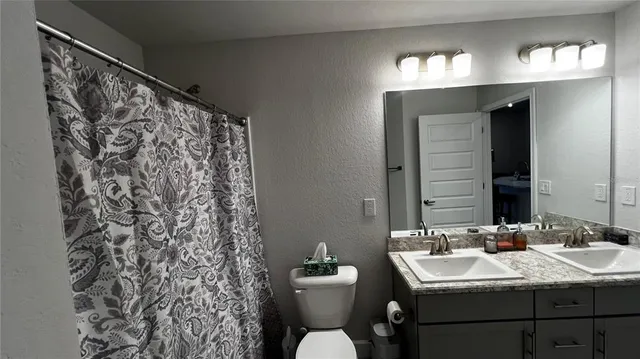 a bathroom with a sink toilet and mirror