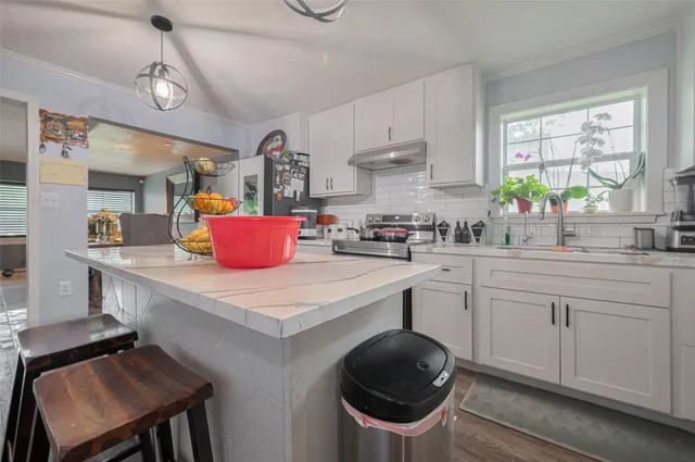 a kitchen with a stove a sink and cabinets