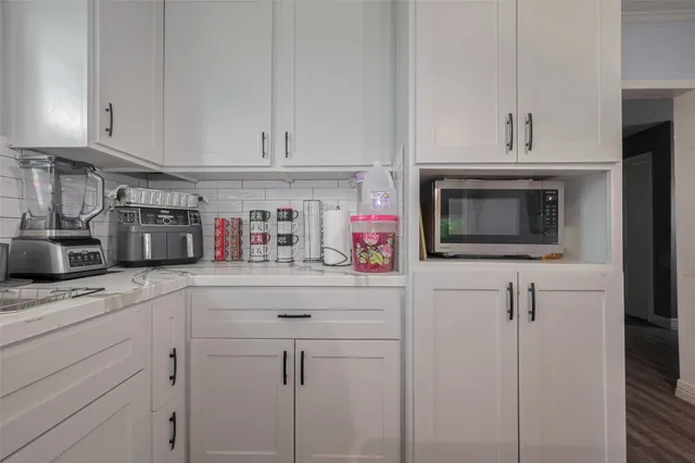 a kitchen with white cabinets and sink