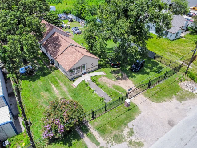 a view of a house with a yard and potted plants