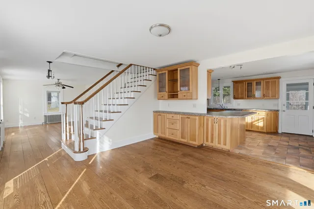 a view of a livingroom with wooden floor and stairs
