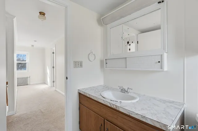 a bathroom with a granite countertop sink and a mirror