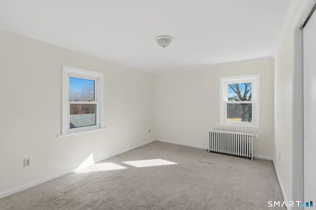 an empty room with windows and closet