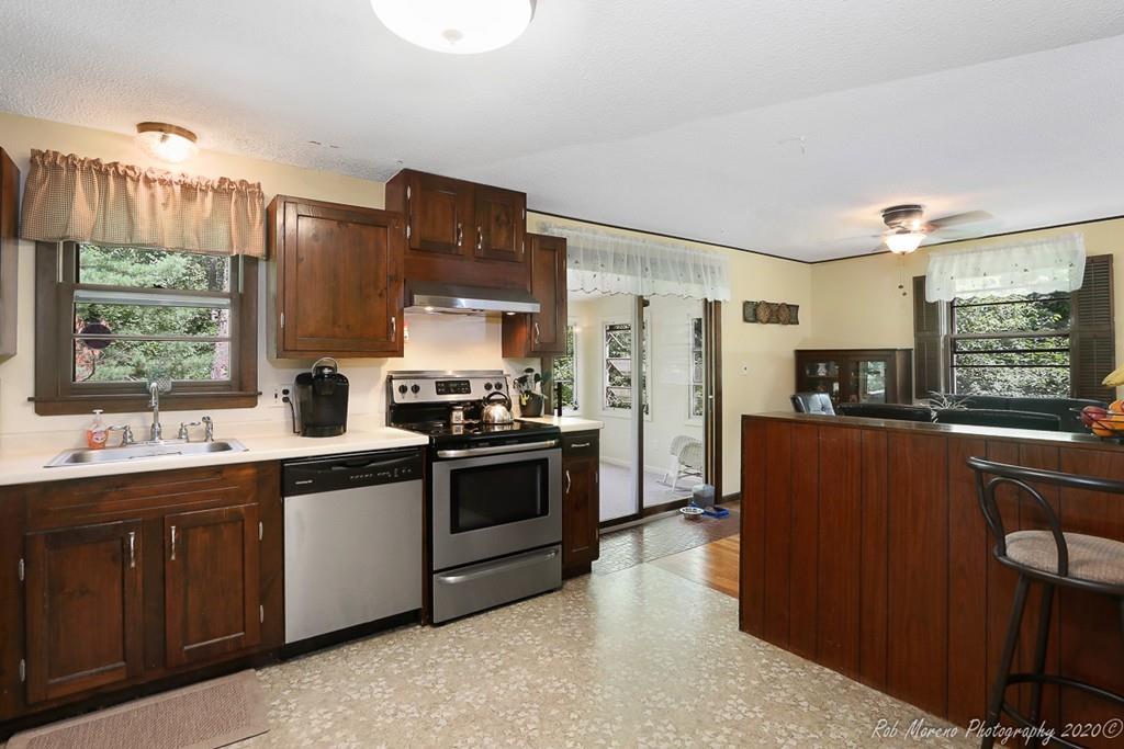 14 Newbury Road Rowley, MA 01969 - Photo 6 of 29 a kitchen with stainless steel appliances granite countertop a refrigerator a sink dishwasher a stove and a dining table with wooden floor