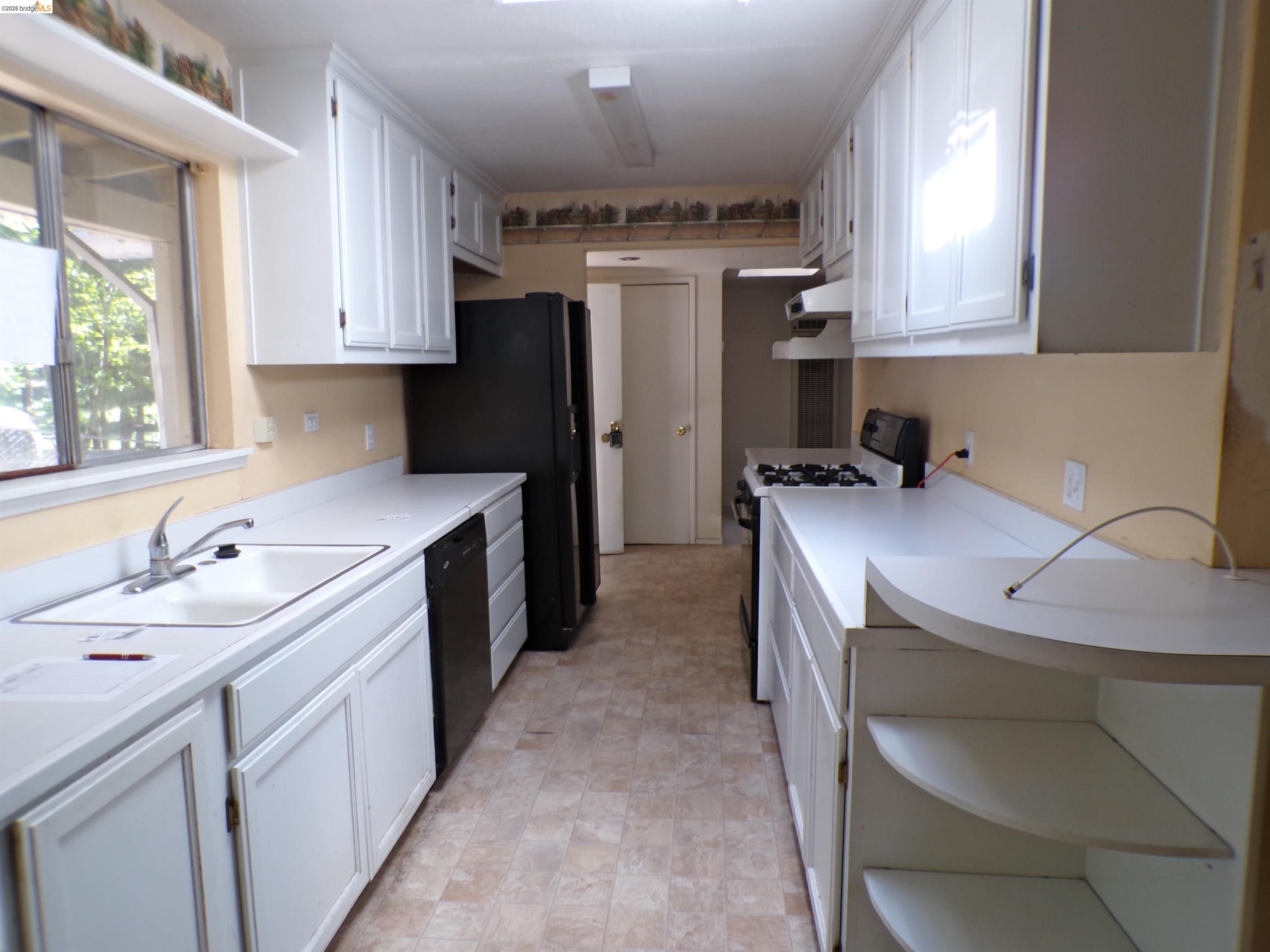 20663 Haiapo Road Mi Wuk Village, CA 95346 - Photo 7 of 24 a kitchen that has a sink a stove and a oven