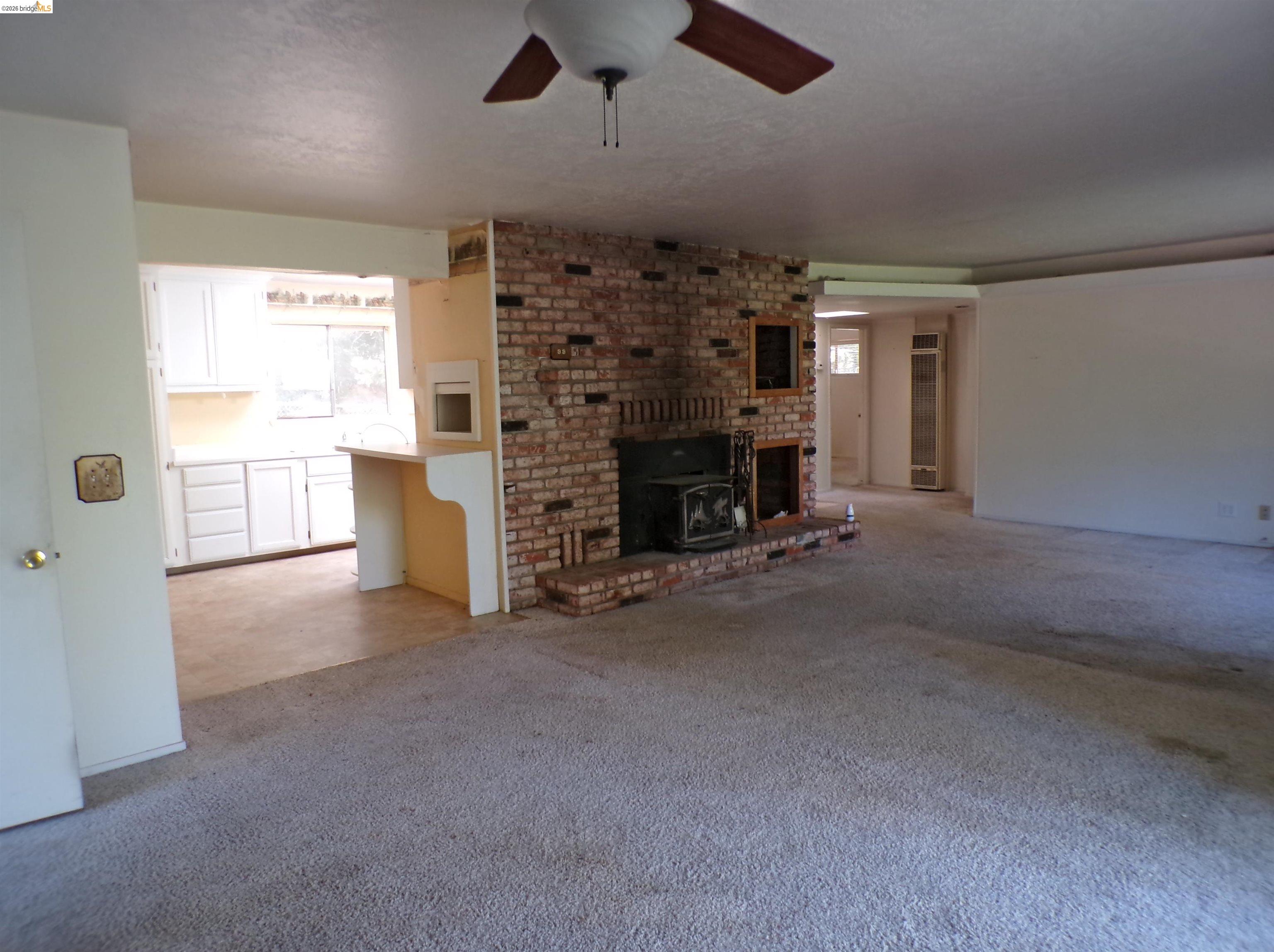 20663 Haiapo Road Mi Wuk Village, CA 95346 - Photo 8 of 24 an empty room with fireplace and windows