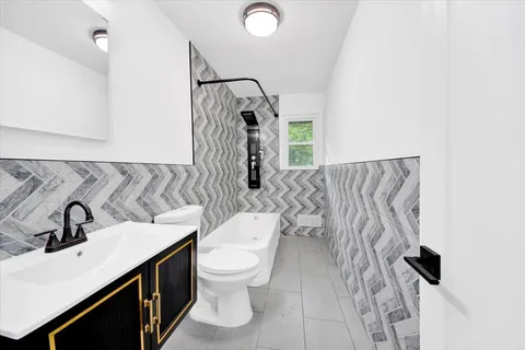 an empty room with wooden floor closet and windows