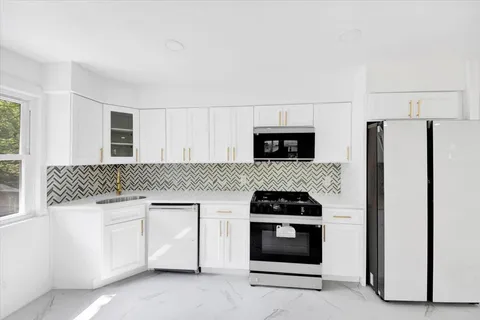 a kitchen with white cabinets and stainless steel appliances