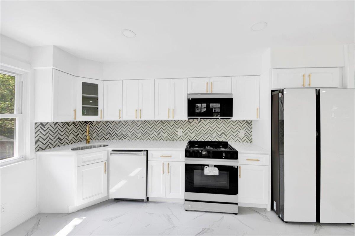 132 Holmes Avenue Hartsdale, NY 10530 - Photo 6 of 34 a kitchen with white cabinets and stainless steel appliances