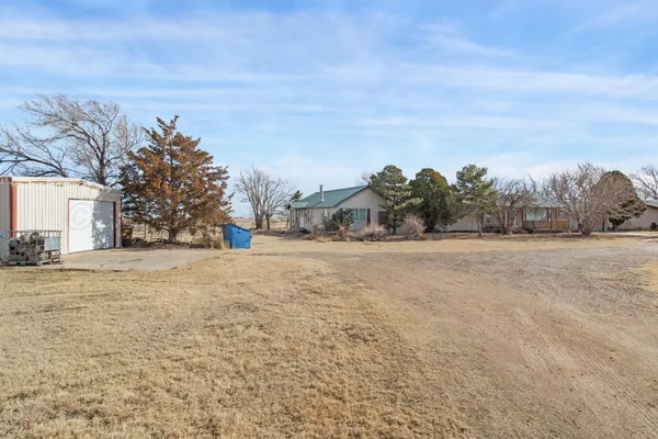a front view of a house with a garden and trees