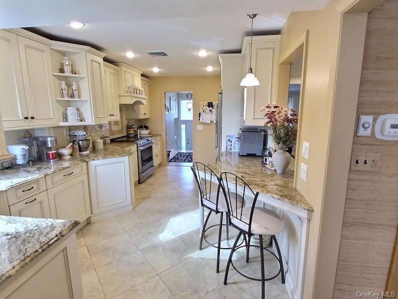 3421 Turf Road Oceanside, NY 11572 - Photo 29 of 50 a kitchen with stainless steel appliances kitchen island granite countertop a refrigerator and microwave