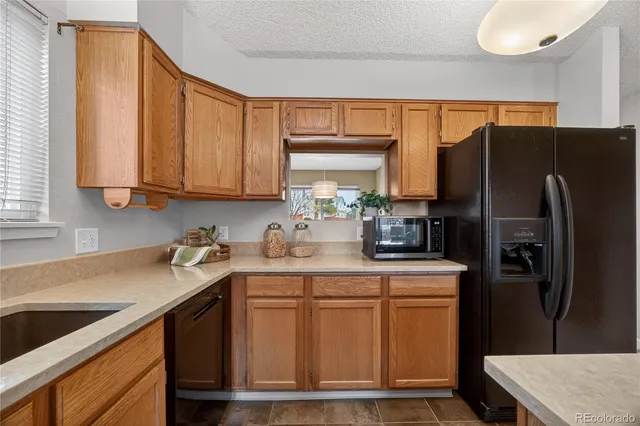 a kitchen with stainless steel appliances granite countertop a refrigerator sink and stove