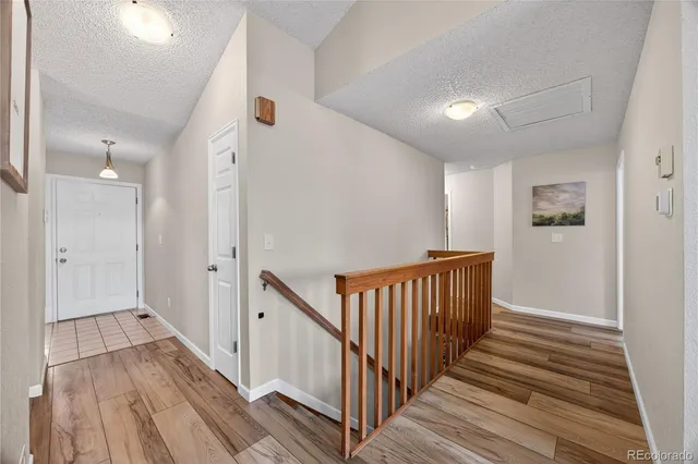 a view of a hallway with wooden floor and staircase