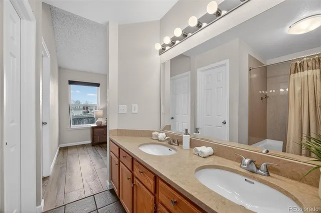 a spacious bathroom with a double vanity sink a mirror and a shower