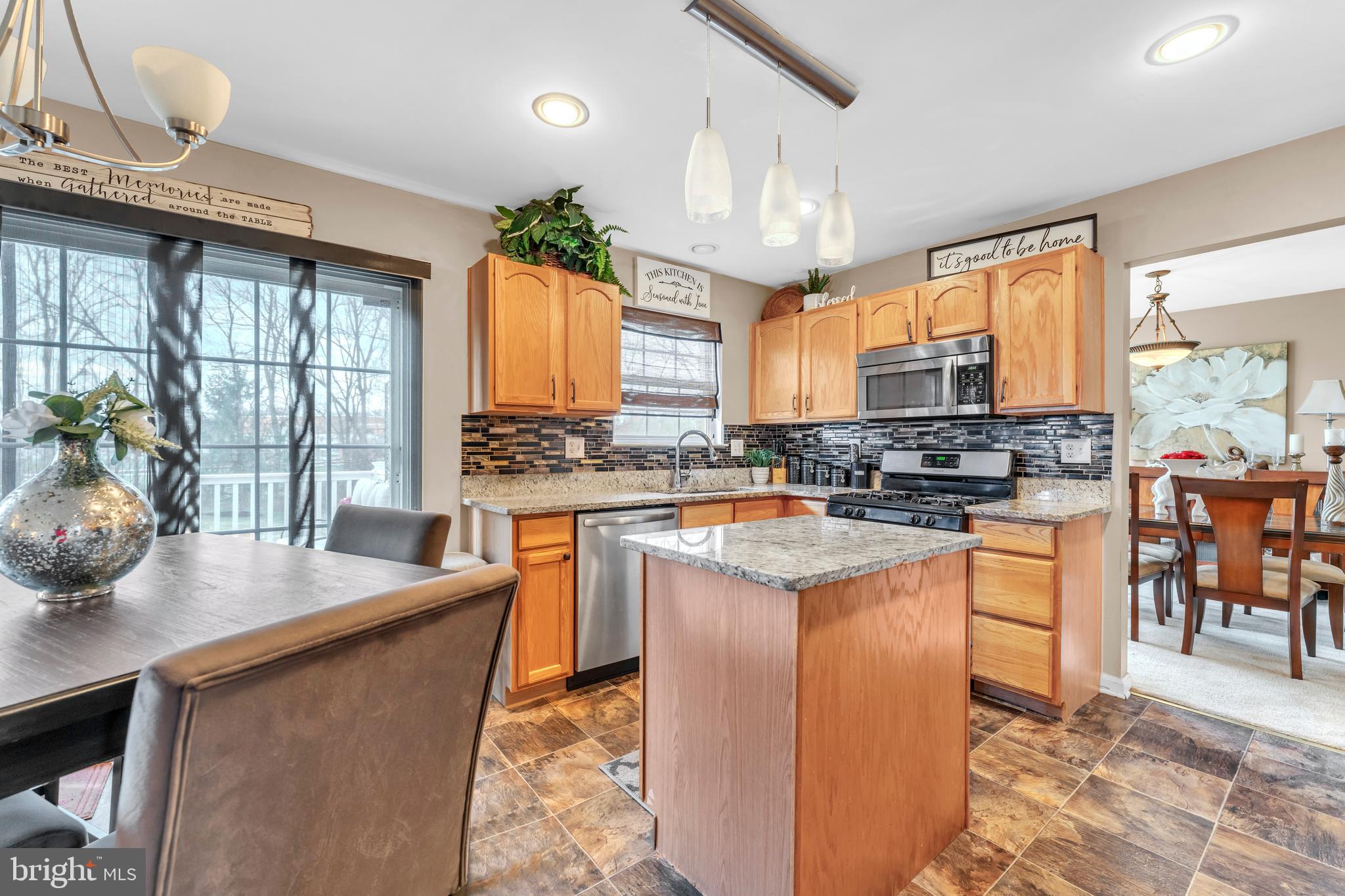 5660 Compton Lane Eldersburg, MD 21784 - Photo 15 of 44 a kitchen with stainless steel appliances a stove a sink a oven a dining table and chairs