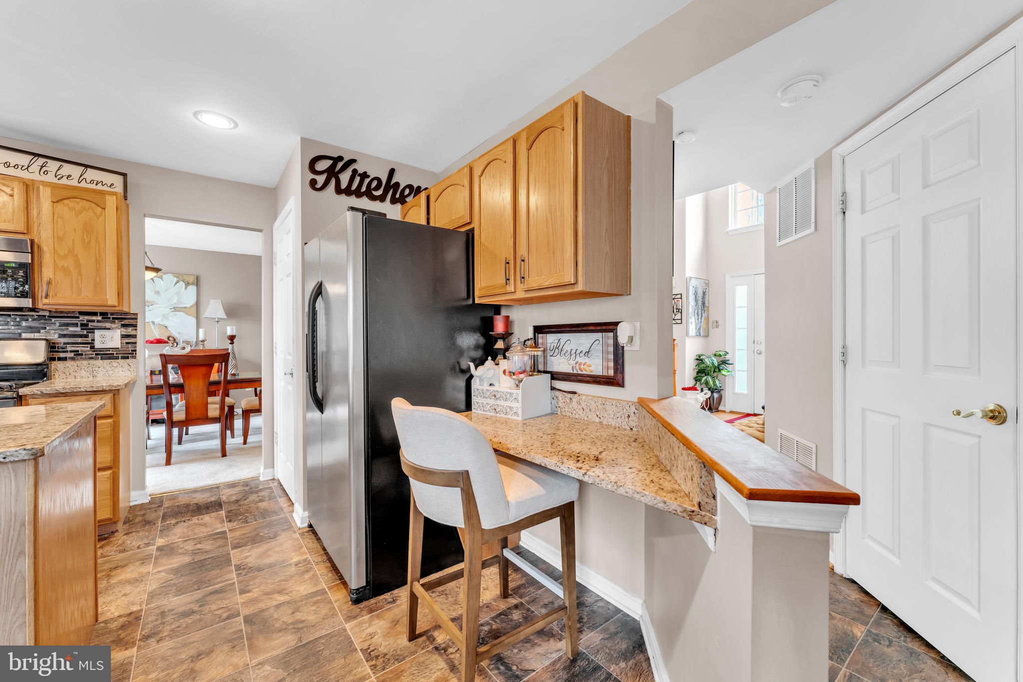 5660 Compton Lane Eldersburg, MD 21784 - Photo 19 of 44 a kitchen with stainless steel appliances granite countertop a refrigerator a stove a sink a dining table and chairs with wooden floor