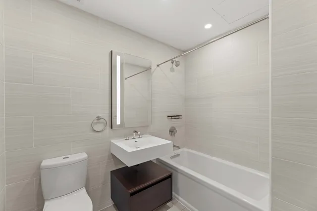 a view of an empty room with wooden floor and stairs