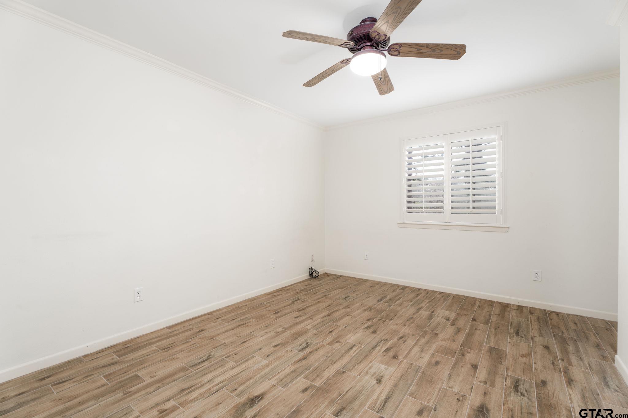 353 Deer Creek Road Big Sandy, TX 75755 - Photo 17 of 30 an empty room with wooden floor ceiling fan and windows