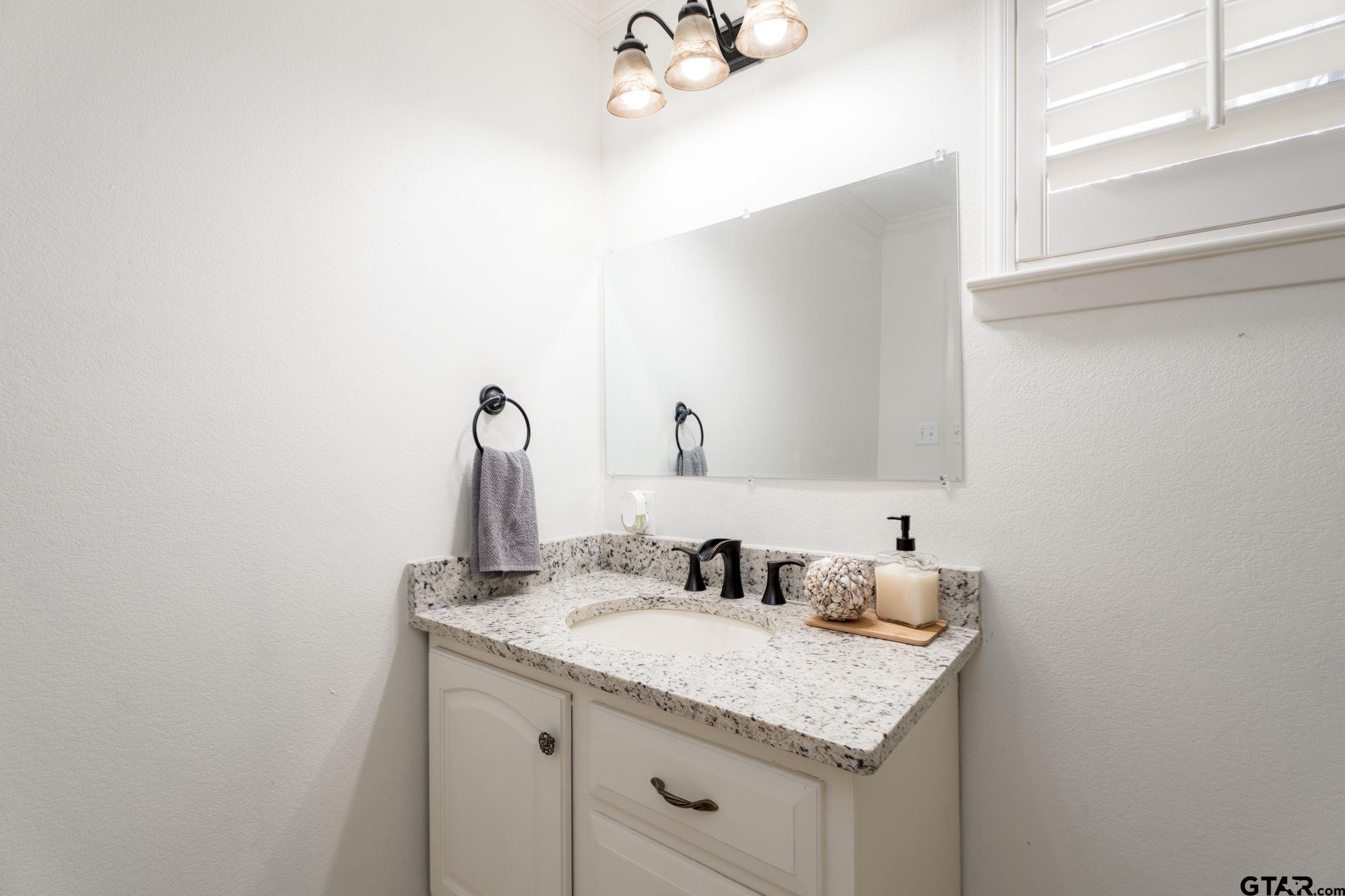 353 Deer Creek Road Big Sandy, TX 75755 - Photo 19 of 30 a bathroom with a granite countertop sink and a mirror