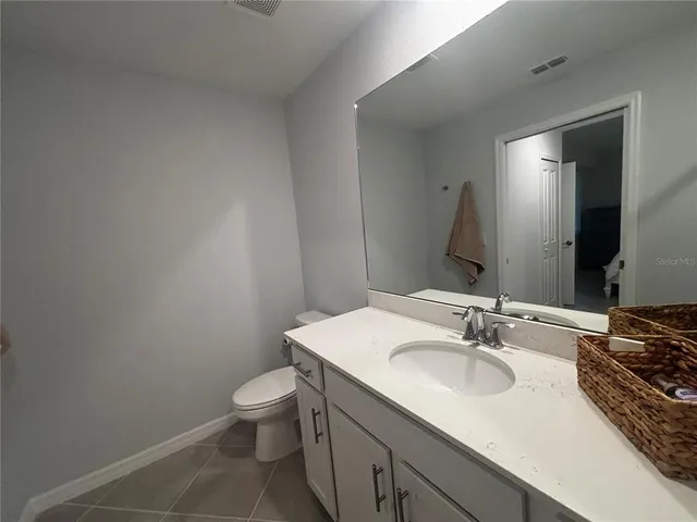 a bathroom with a granite countertop sink toilet and mirror