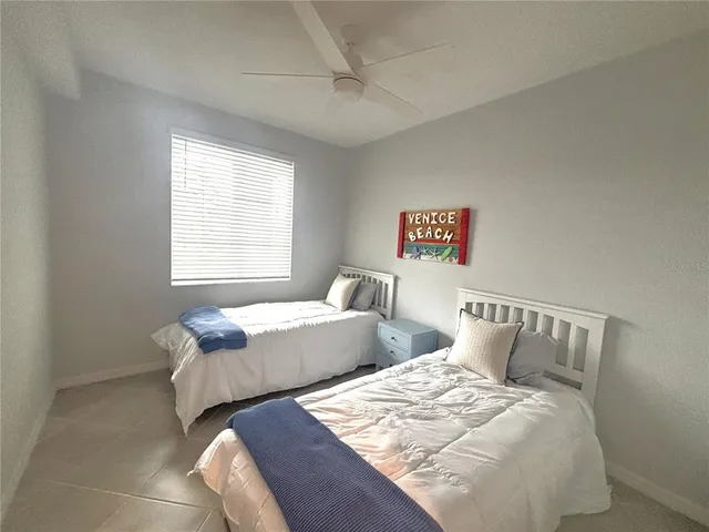 a bedroom with two beds and a window