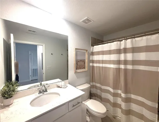 a bathroom with a sink a toilet a shower and a mirror