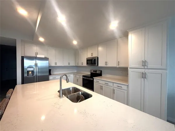 a kitchen with granite countertop a sink stainless steel appliances and cabinets