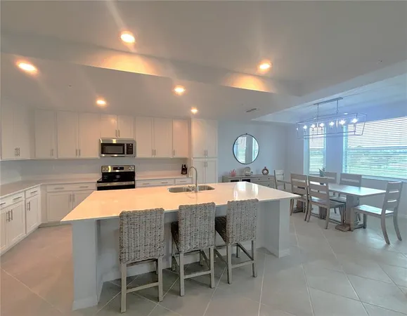 a large dining hall with stainless steel appliances a dining table and chairs