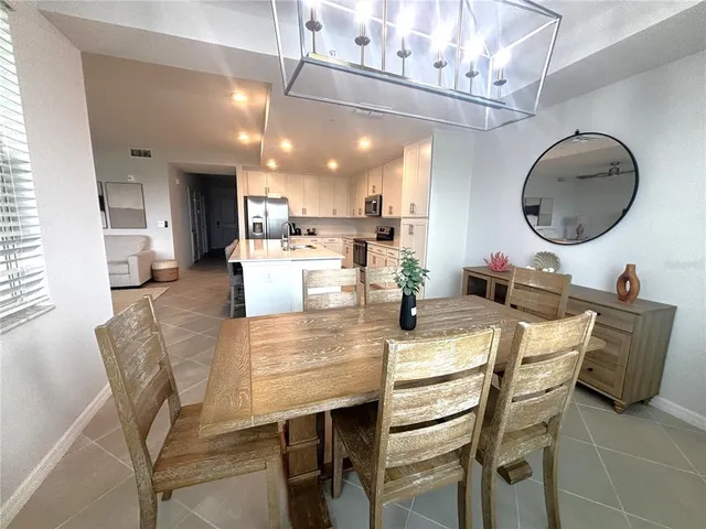 a dining room with stainless steel appliances kitchen island a table and chairs