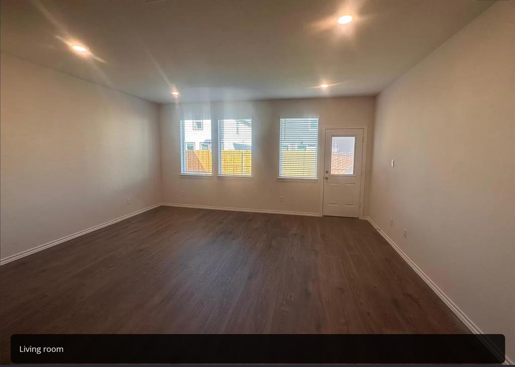 6015 Pinion Trail Princeton, TX 75407 - Photo 3 of 17 an empty room with wooden floor and windows
