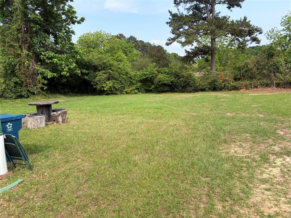 410 Patrick Street Minden, LA 71055 - Photo 4 of 9 Expansive grassy yard area with a rustic wood-plank picnic table