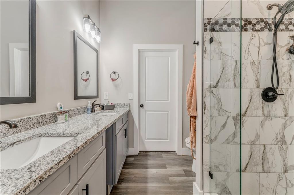 1172 Hunter Drive Ranger, GA 30734 - Photo 39 of 71 a bathroom with a granite countertop sink a mirror and shower