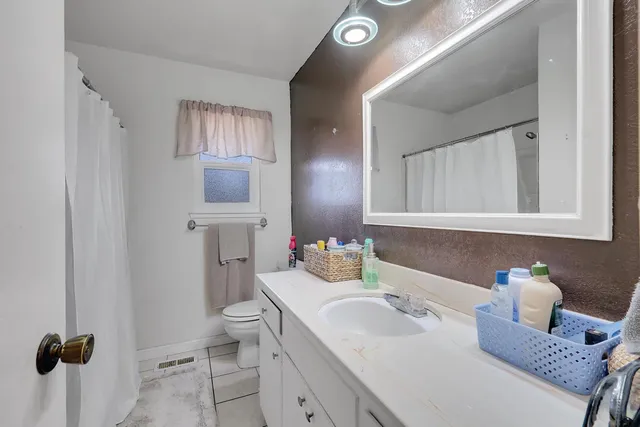 a bathroom with a sink toilet and mirror