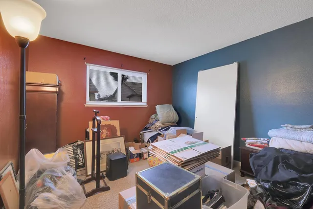 a living room with furniture and a painting on the wall